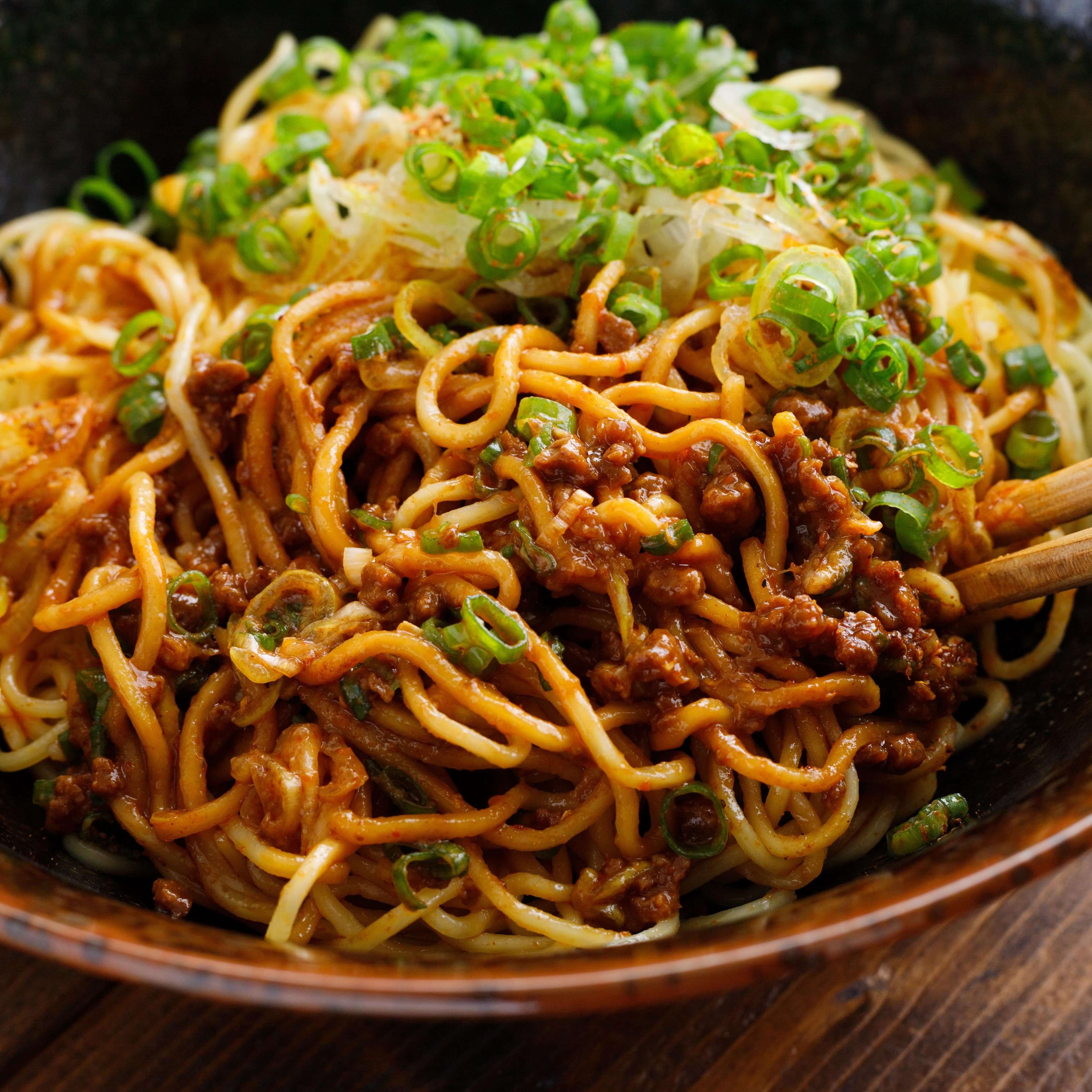 Caramelised pork topped with spring onions in soy sauce noodles.